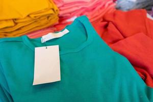 Étiquette de vêtements blancs vierges sur une nouvelle chemise en magasin photo