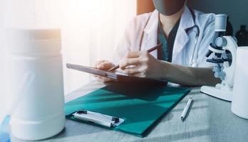 médecine médecin ou pharmacien utilise une tablette ou un téléphone portable. concept de soins de santé et d'assurance médicale ou maladie. photo