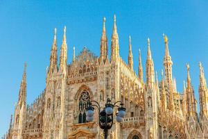 célèbre église cathédrale de milan duomo di milano avec des flèches gothiques et des statues de marbre blanc. principale attraction touristique sur la piazza à milan lombardie italie. vue grand angle de l'architecture et de l'art gothiques anciens photo