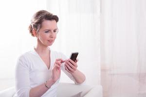 femme forte lit un message sur smartphone