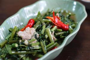 La gloire du matin sautée dans un plat noir La gloire du matin sautée est également l'un des plats les plus délicieux que vous puissiez manger en Thaïlande. photo