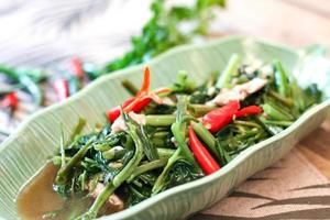 La gloire du matin sautée dans un plat noir La gloire du matin sautée est également l'un des plats les plus délicieux que vous puissiez manger en Thaïlande. photo