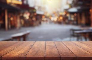 dessus de table en bois vide sur flou abstrait du restaurant de rue en plein air et arrière-plan de la ville, pour l'affichage du produit de montage, rendu 3d photo