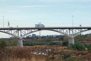 pont moderne sur une rivière sur laquelle passent de gros véhicules et des touristes. photo