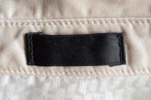 étiquette de vêtements de soin de lessive noire vierge sur la texture du tissu photo