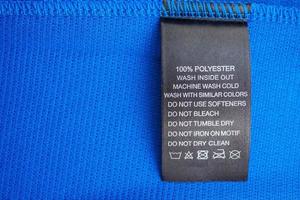 Entretien du linge noir instructions de lavage étiquette de vêtements sur la chemise de sport en jersey polyester bleu photo