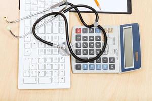 stéthoscope sur clavier, calculatrice et presse-papiers photo