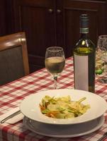 pâtes italiennes et verre de vin sur la table du restaurant photo