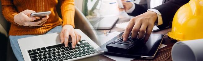 Deux collègues discutant des données de travail et tablette, ordinateur portable avec sur le projet architectural sur le chantier de construction au bureau au bureau photo