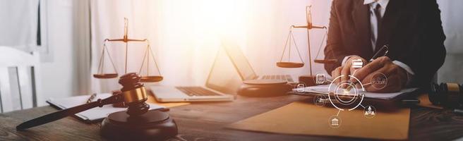 concept de justice et de droit. juge masculin dans une salle d'audience avec le marteau, travaillant avec, clavier d'ordinateur et d'accueil, lunettes, sur table à la lumière du matin photo