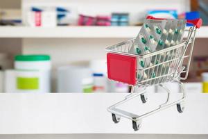 capsule de pilules de médecine dans le panier sur le comptoir du magasin de pharmacie avec des étagères de pharmacie floues arrière-plan défocalisé photo