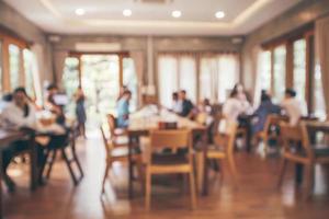 intérieur du restaurant avec client et table en bois flou fond abstrait avec lumière bokeh photo