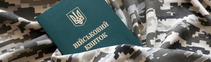 carte d'identité militaire ukrainienne sur tissu avec texture de camouflage pixélisé. tissu avec motif camouflage en formes de pixels gris, marron et vert avec jeton personnel de l'armée ukrainienne photo
