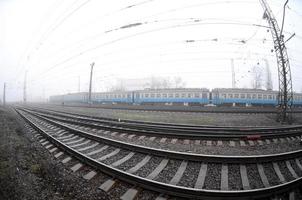 le train de banlieue ukrainien se précipite le long de la voie ferrée par un matin brumeux. photo fisheye avec distorsion accrue