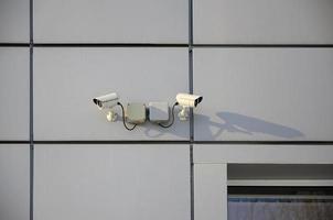 caméra de surveillance blanche intégrée dans le mur métallique de l'immeuble de bureaux photo