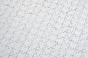 Close up texture d'un puzzle blanc à l'état assemblé. vue de dessus. de nombreux composants d'une grande mosaïque entière sont unis photo