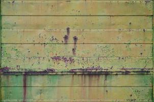 texture d'un vieux mur de métal jaune avec des dommages importants dus à l'exposition à des conditions météorologiques défavorables et à l'humidité photo