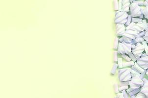 guimauve colorée disposée sur fond de papier citron vert. texture créative pastel photo