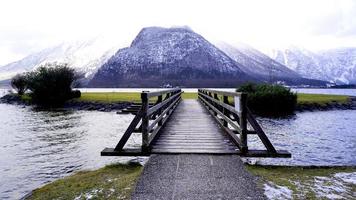 pont en bois menant au paysage du lac hallstatt avec des montagnes enneigées, hallstatt, autriche photo