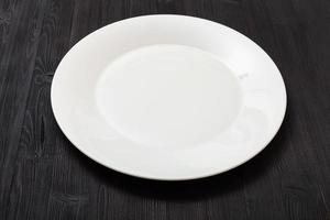 assiette blanche sur table marron foncé photo