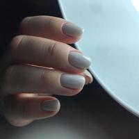 mains de femme avec des ongles blancs sur le fond sombre photo