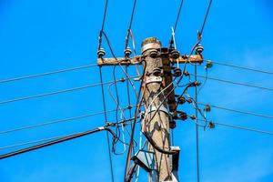 lignes électriques de poteau électrique fils électriques sortants contre le ciel bleu nuageux. photo