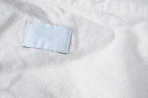 étiquette blanche de vêtements de soin de blanchisserie vierge sur une chemise en coton photo