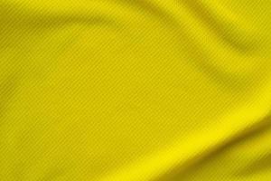 tissu de vêtements de sport de couleur jaune maillot de football texture vue de dessus gros plan photo