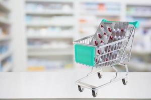 capsule de pilules de médecine dans le panier sur le comptoir du magasin de pharmacie avec des étagères de pharmacie floues arrière-plan défocalisé photo