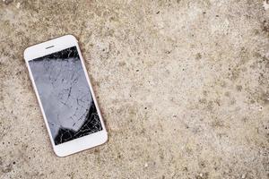 verre brisé d'écran de téléphone portable sur fond de sol en béton photo