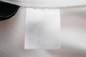étiquette de vêtement vierge blanche sur fond de chemise en coton photo