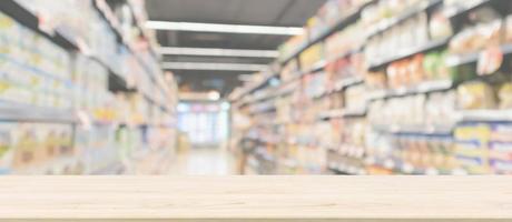 dessus de table en bois vide avec allée de supermarché avec étagères de produits intérieur arrière-plan flou défocalisé photo