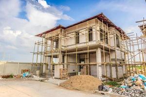 construction d'une nouvelle maison résidentielle en cours sur le chantier avec nuages et ciel bleu photo