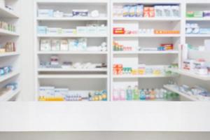 Table de comptoir de pharmacie de pharmacie avec fond abstrait flou avec des médicaments et des produits de santé sur des étagères photo