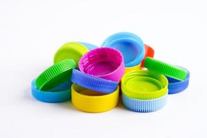 bouchons de bouteilles en plastique colorés pour recyclage sur fond blanc. photo