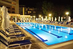 bulgarie, laguna park. 10.06.2022. soirée au bord de la piscine dans un hôtel de luxe. piscine avec transats et parasols fermés. photo