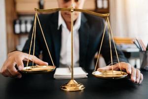 avocat masculin au bureau avec échelle en laiton sur table en bois. concept de justice et de droit à la lumière du matin photo