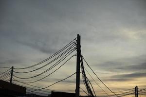 fils électriques sur poteau. de nombreux fils contre le ciel. photo