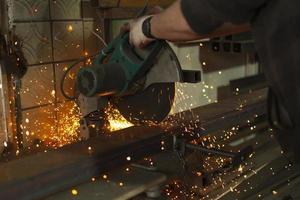 sciage de l'acier. scie circulaire et étincelles. détails de fabrication. Coupe de métal. photo