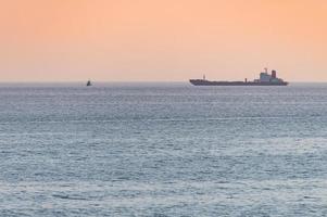 petit remorqueur et grand cargo. beau coucher de soleil sur la mer. vue de voyage à couper le souffle, espace de copie. photo