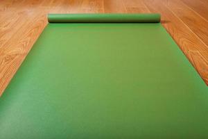 tapis de yoga vert sur plancher en bois déplié. mode de vie sain, fitness, sports. photo