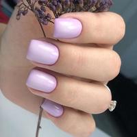 manucure violette féminine à la mode élégante. mains d'une femme avec manucure violette sur les ongles photo