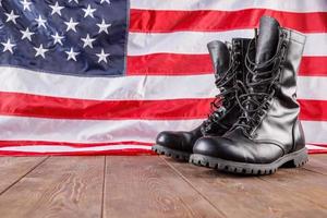 Bottines noires devant nous drapeau sur la surface en bois photo