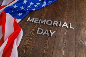 les mots jour du souvenir posés avec des lettres en métal argenté sur la surface de la planche de bois avec le drapeau usa froissé photo