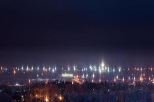 paysage urbain d'hiver de nuit avec des piliers de lumière phénomène atmosphérique photo