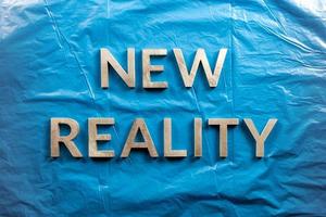 les mots nouvelle réalité posés avec des lettres blanches sur fond de film plastique bleu froissé photo