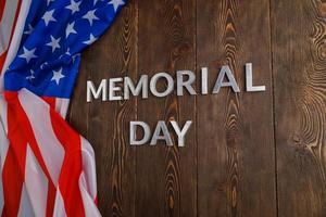 les mots jour du souvenir posés avec des lettres en métal argenté sur la surface de la planche de bois avec le drapeau usa froissé photo