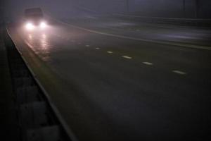 monospace seul se déplaçant sur une route brumeuse de nuit vide photo