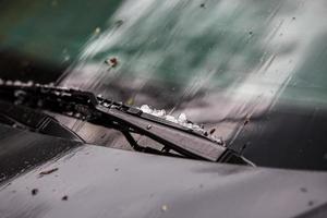 Petites boules de glace de grêle sur capot de voiture noir après une forte tempête estivale photo