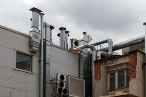 anciens conduits d'air de ventilation extérieurs et climatiseurs à l'extérieur du mur arrière de la cuisine du café photo